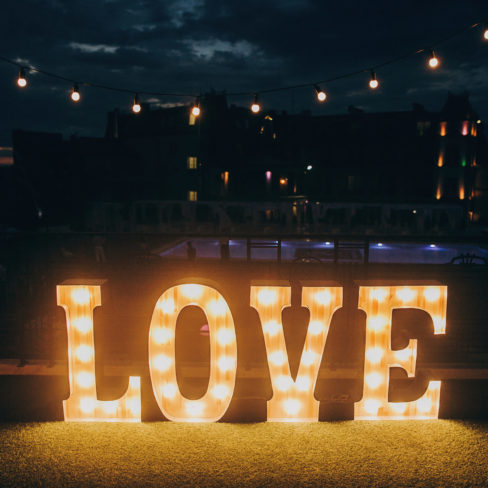 big white love letters in light bulbs for photo booth at wedding big white love letters in light bulbs for photo booth at wedding reception in night outdoors. love word lights, stylish evening decor for wedding ceremony